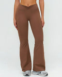 Front view of ruched high waist flare yoga leggings in brown, featuring a sculpting V-shaped ruched waistband and flared leg silhouette paired with grey sneakers.