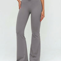 Front view of grey ruched high waist flare yoga leggings featuring a sculpting V-shaped waistband and flared leg silhouette, paired with grey sneakers.