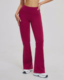 Front view of flare high waist sculpting yoga leggings in burgundy, featuring a wide compression waistband and flared leg silhouette paired with white sneakers.