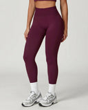 Front view of seamless high waist sculpting compression leggings in burgundy, showing smooth no-seam construction and wide waistband, paired with white socks and sneakers.