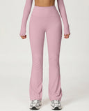Front view of pink flare high waist sculpt yoga leggings with wide waistband and bootcut leg opening, paired with a matching long-sleeve top and sneakers.