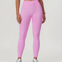 Front view of seamless high waist sculpting compression leggings in pink, showing full-length fit with ribbed waistband and ankle-length silhouette paired with sneakers.
