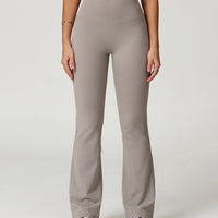 Front view of grey flare high waist sculpting leggings with wide waistband and bootcut leg, paired with white sneakers.