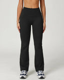 Front view of black flare high waist sculpting yoga leggings with a smooth compression fit and lengthening flare leg silhouette, paired with sneakers.