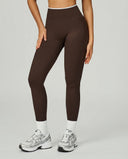Front view of seamless high waist sculpting compression leggings in brown, styled with white socks and New Balance sneakers showing the full-length squat-proof fit.