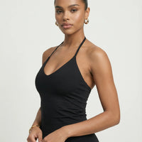 Model wearing a black seamless halter sculpt leggings set with high waist fitted leggings and athletic sneakers.