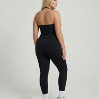 Model wearing a black seamless halter sculpt leggings set with high waist fitted leggings and athletic sneakers.