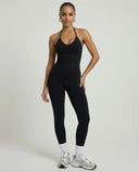 Model wearing a black seamless halter sculpt leggings set with high waist fitted leggings and athletic sneakers.