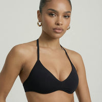 Model wearing a black seamless sculpt gym set with high waist shorts and a supportive sports bra paired with athletic sneakers.