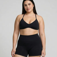 Model wearing a black seamless sculpt gym set with high waist shorts and a supportive sports bra paired with athletic sneakers.