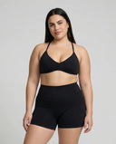 Model wearing a black seamless sculpt gym set with high waist shorts and a supportive sports bra paired with athletic sneakers.