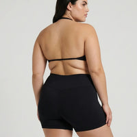 Model wearing a black seamless sculpt gym set with high waist shorts and a supportive sports bra paired with athletic sneakers.