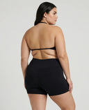 Model wearing a black seamless sculpt gym set with high waist shorts and a supportive sports bra paired with athletic sneakers.