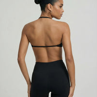 Model wearing a black seamless sculpt gym set with high waist shorts and a supportive sports bra paired with athletic sneakers.