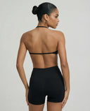 Model wearing a black seamless sculpt gym set with high waist shorts and a supportive sports bra paired with athletic sneakers.