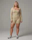 Woman wearing a long sleeve compression shorts sculpting romper designed for activewear and athleisure use.