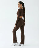 Woman wearing a fitted long sleeve crop top and high waist flare leggings activewear set styled with athletic sneakers.