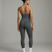 Model wearing a gray seamless halter sculpt leggings set with high waist fitted leggings and athletic sneakers.