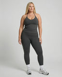 Model wearing a gray seamless halter sculpt leggings set with high waist fitted leggings and athletic sneakers.
