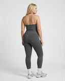 Model wearing a gray seamless halter sculpt leggings set with high waist fitted leggings and athletic sneakers.
