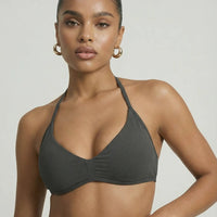 Model wearing a grey seamless sculpt gym set with high waist shorts and a supportive sports bra paired with athletic sneakers.