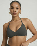 Model wearing a grey seamless sculpt gym set with high waist shorts and a supportive sports bra paired with athletic sneakers.