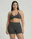 Model wearing a grey seamless sculpt gym set with high waist shorts and a supportive sports bra paired with athletic sneakers.