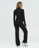 Seen women's 3-piece set with flare pants, sports bra, and jacket, displayed on a mannequin in a casual indoor setting.