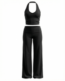Seen flare yoga pants set with high waist and halter sports bra, shown in black fabric on a model.