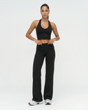 Seen flare yoga pants set with high waist and halter sports bra, shown on a model in a fitness studio.