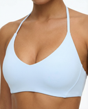 Seen women's seamless wireless sports bra with halter triangle design, shown in black with smooth fabric and supportive fit.