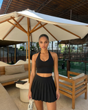 Seen women's tennis skirt set with high waist and halter crop top, featuring sporty design and comfortable fit.