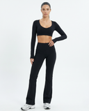 Seen flare yoga pants set with high waist and long sleeve crop top, shown in black on a model.