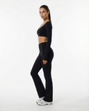 Seen flare yoga pants set featuring high waist flare pants and long sleeve crop top, shown in black on a model.