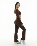 Seen flare yoga pants set with high waist and long sleeve crop top, featuring a comfortable, stylish workout outfit.