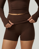Seen women's workout set with long sleeve top and biker shorts, featuring a sleek, fitted design in breathable athletic fabric.