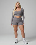 Seen women's activewear set with black sculpting biker shorts and long sleeve top, designed for workout and athleisure wear.
