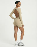 Woman wearing a long sleeve compression shorts sculpting romper designed for activewear and athleisure use.