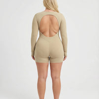 Woman wearing a long sleeve compression shorts sculpting romper designed for activewear and athleisure use.