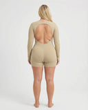 Woman wearing a long sleeve compression shorts sculpting romper designed for activewear and athleisure use.