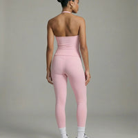 Model wearing a pink seamless halter sculpt leggings set with high waist fitted leggings and athletic sneakers.