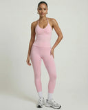 Model wearing a pink seamless halter sculpt leggings set with high waist fitted leggings and athletic sneakers.