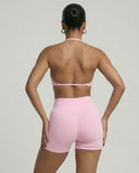 Model wearing a pink seamless sculpt gym set with high waist shorts and a supportive sports bra paired with athletic sneakers.