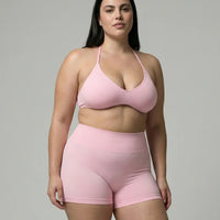 Model wearing a pink seamless sculpt gym set with high waist shorts and a supportive sports bra paired with athletic sneakers.