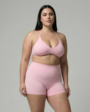 Model wearing a pink seamless sculpt gym set with high waist shorts and a supportive sports bra paired with athletic sneakers.