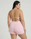Model wearing a pink seamless sculpt gym set with high waist shorts and a supportive sports bra paired with athletic sneakers.