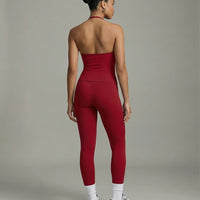 Model wearing a red seamless halter sculpt leggings set with high waist fitted leggings and athletic sneakers.