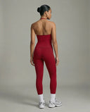 Model wearing a red seamless halter sculpt leggings set with high waist fitted leggings and athletic sneakers.