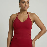 Model wearing a red seamless halter sculpt leggings set with high waist fitted leggings and athletic sneakers.