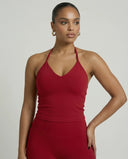 Model wearing a red seamless halter sculpt leggings set with high waist fitted leggings and athletic sneakers.